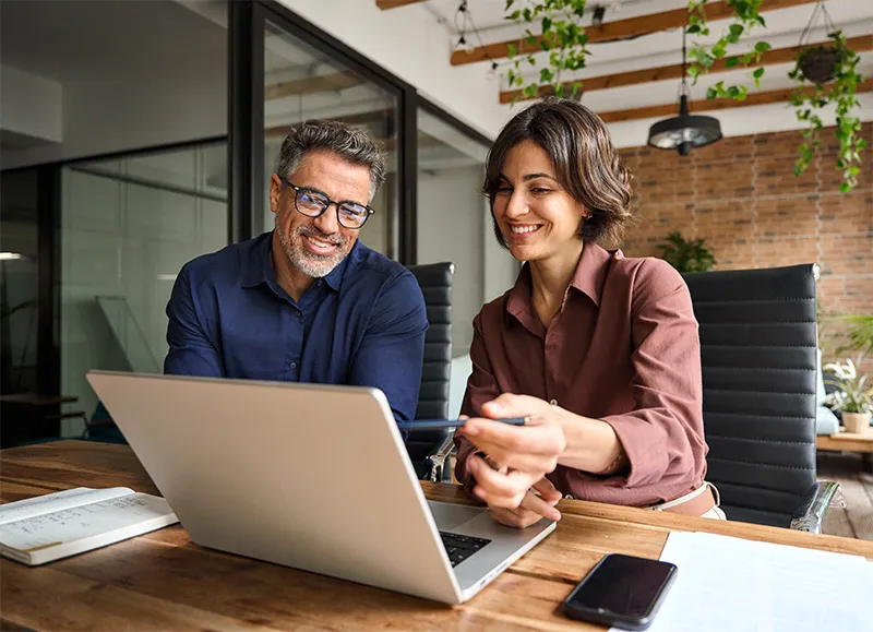 Two people discussing taxes in front of the computer